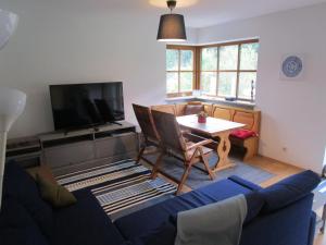 ein Wohnzimmer mit einem blauen Sofa und einem Tisch in der Unterkunft Hammerhaus-Apartment 3 in Siegsdorf