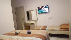 ein Hotelzimmer mit 2 Betten und einem TV an der Wand in der Unterkunft Apartments Ardoni in Ulcinj