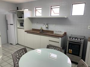 a kitchen with a table and a table and chairs at Apartamento amplo com acesso direto à praia! in Cabedelo