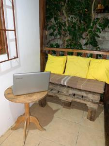 un ordenador portátil sentado en una mesa junto a un sofá en La posada de Mary, en Montañita