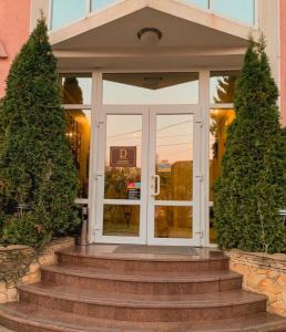 a front door of a building with two trees at Hotel DENINNA in Vinnytsya