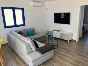 sala de estar con sofá y TV de pantalla plana en SEA FRONT Apartamento frente al mar, en Playa Honda