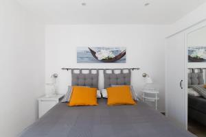 a bedroom with a bed with two orange pillows at Attico panoramico Sorrento in Meta