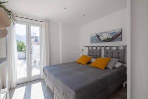 sypialnia z łóżkiem z 2 żółtymi poduszkami w obiekcie Attico panoramico Sorrento w mieście Meta