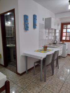 una cocina con mesa blanca y sillas. en Pousada Baleia Franca Canasvieiras, en Florianópolis