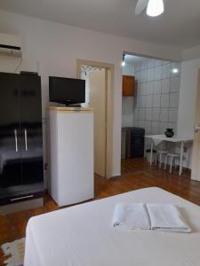 sala de estar con cama blanca y cocina en Pousada Baleia Franca Canasvieiras en Florianópolis