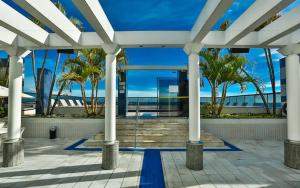 a view of a building with palm trees and the ocean at Condomínio Master Metropolitan -Centro de Brasília in Brasilia