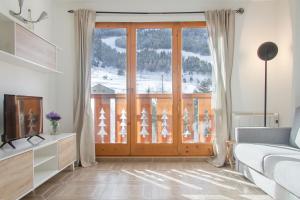 sala de estar con una gran puerta de cristal y balcón en Apartamento Tarter Parc 1 habitación, en Canillo