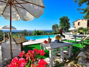een patio met een tafel, een parasol en een zwembad bij Splendid Holiday Home in Rignano Sull Arno FI with Garden in San Cristoforo a Perticaia