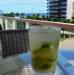 a drink sitting on a glass table on a balcony at Apto Frente ao Mar in Bertioga