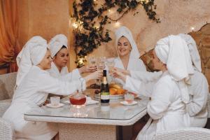 a group of women in white drinking wine at a table at Hotel & Spa DENINNA in Vinnytsya