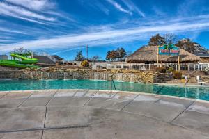 a resort with a swimming pool with a thatch roof at Screened Deck Margaritaville Lake Resort Retreat! in Osage Beach