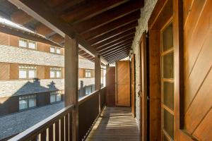 un porche vacío de un edificio con puerta de madera en Refugi d Inclès 1 habitación en El Tarter
