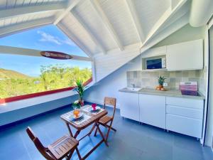 eine Küche mit einem Tisch und Stühlen sowie einem großen Fenster in der Unterkunft Beautiful suite S18, pool, sea view, next to paradise Pinel Island in Cul de Sac