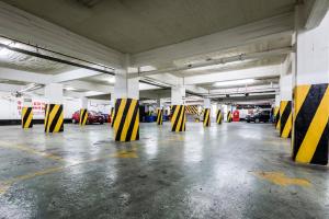 an empty parking garage with yellow and black pillars at Hi Hotel Impala Queretaro in Querétaro