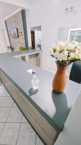 a vase with flowers on a table in a lobby at Nacional Park Hotel Lages in Lages
