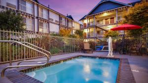 a swimming pool with an umbrella next to a building at Best Western Plus Bayshore Inn in Eureka