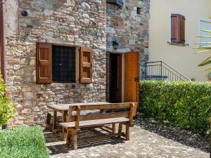 eine Holzbank vor einem Steingebäude in der Unterkunft Belvilla by OYO Nord in Castellarano
