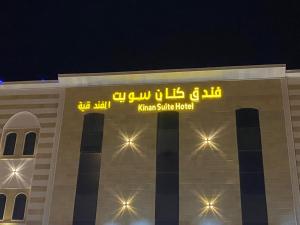 a building with a sign on top of it at night at فندق كنان سويت in Sulţānah