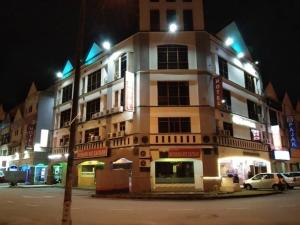 un edificio en una esquina por la noche en HOTEL SRI SUTRA (BANDAR SUNWAY) en Petaling Jaya