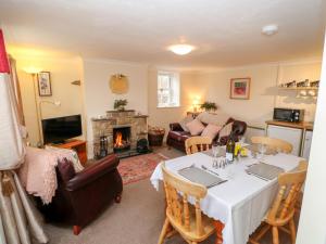 a living room with a table and a fireplace at Lonin Cottage in Barnard Castle