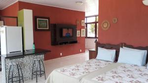 a bedroom with red walls and a bed and a tv at Tapuio Park Hotel in Cavalcante