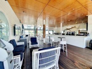 a restaurant with white chairs and tables and a bar at Couran Cove Resort in Gold Coast
