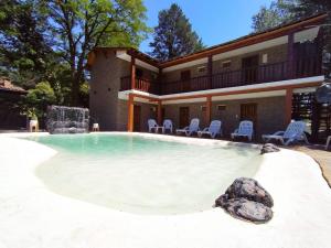 a house with a swimming pool in the backyard at Hotel Berlin in Villa General Belgrano
