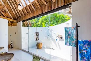 a glass shower in a room with a window at Koh Yao Yai Village - SHA Extra Plus in Ko Yao Yai