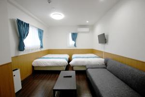 ein Wohnzimmer mit 2 Betten und einem Sofa in der Unterkunft Phoenix Ryukyu Henzanbaru -SEVEN Hotels and Resorts- in Chatan