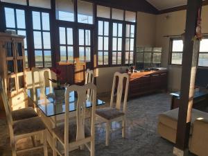 a dining room with a glass table and chairs at Casa em frente a praia de Jaconé in Saquarema