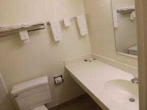 a white toilet sitting next to a white sink at Tristar Inn Xpress in Tucumcari