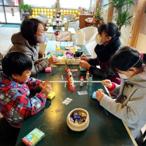 um grupo de crianças sentadas à mesa a brincar com brinquedos em yado & kissa UGO HUB em Yuzawa