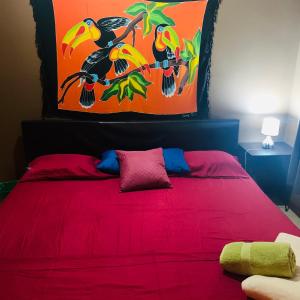 a bedroom with a red bed with a red blanket at Around Juan Santa María in Alajuela