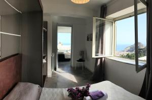 a bedroom with a bed and a large window at Villa la Vista - by Vacation Service in Cefalù