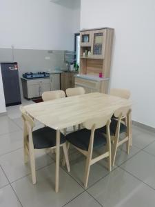 a wooden table and chairs in a kitchen at FZ Almyra Homestay in Kajang