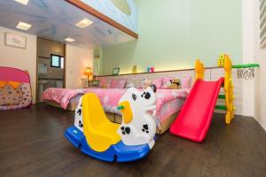 a childs bedroom with a bed and two play equipment at 曉翠軒親子民宿 in Wujie