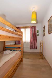 ein Schlafzimmer mit einem Etagenbett aus Holz und einem Fenster in der Unterkunft Ferienwohnung Gartenweg in Adelboden