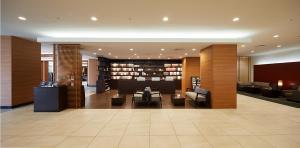 a lobby with a library with couches and chairs at Almont Hotel Kyoto in Kyoto
