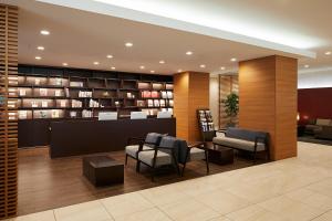 a lobby with a waiting room with chairs and books at Almont Hotel Kyoto in Kyoto