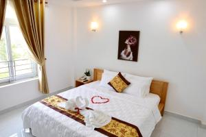 a bedroom with a bed with white sheets and a window at Khách sạn Thái Bình in Con Dao