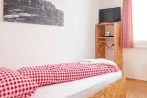 1 dormitorio con colcha roja y blanca a cuadros en der GASTHOF en Bürglen