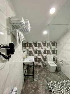 een witte badkamer met een wastafel en een toilet bij Max Spa Hotel in Nevinnomyssk