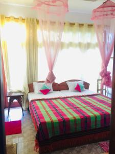 een slaapkamer met een bed met een kleurrijke deken bij Kandy IVY Banks Holiday Resort in Kandy