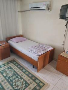 a small bedroom with a bed and a tv at Hasyurt Hotel in Finike