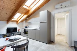 a kitchen with white cabinets and a table with chairs at Dreams Hotel Residenza Pianell 10 in Milan