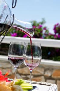 two glasses of red wine are sitting on a table at Paros Agnanti Resort & Spa in Parikia