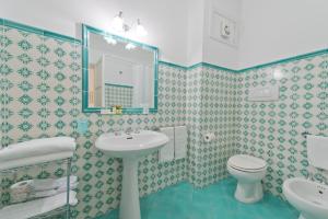 a bathroom with a sink and a toilet and a mirror at Casa Stella Marina in Praiano