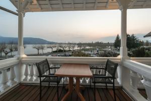 une terrasse couverte avec une table et des chaises et une vue sur l'eau dans l'établissement Le Bel Abri, à Annecy