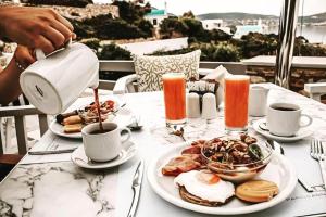 a person pouring coffee into a plate of food on a table at Paros Agnanti Resort & Spa in Parikia